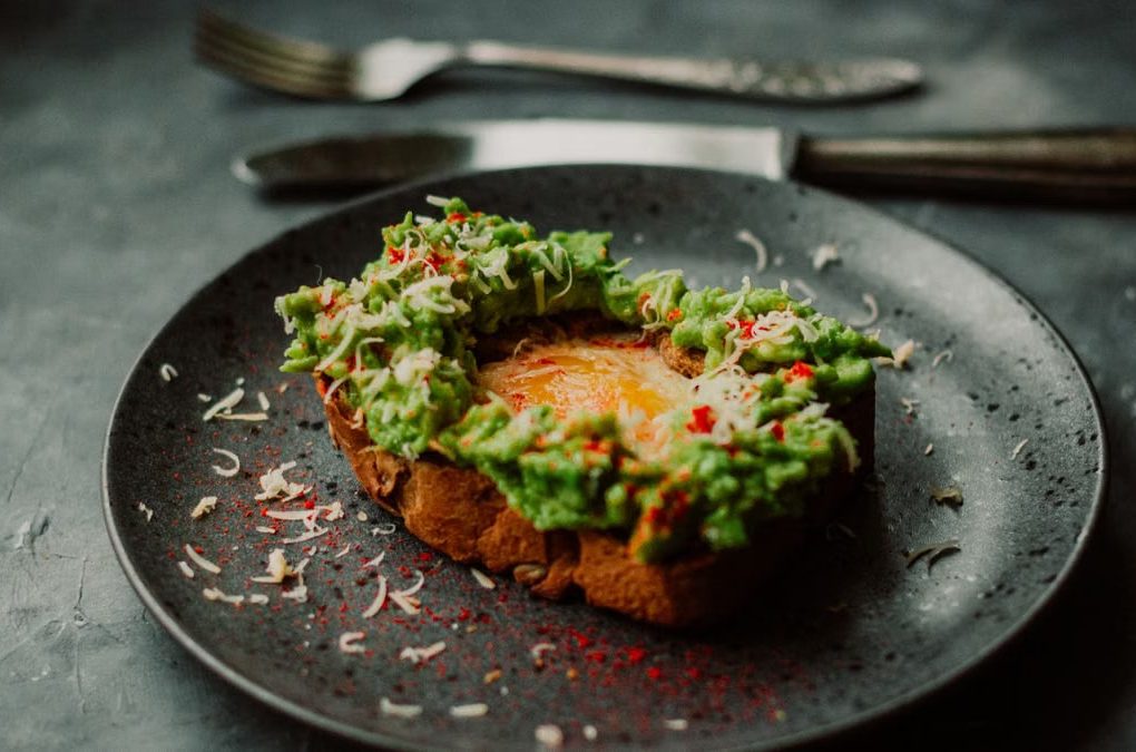 Delicious avocado toast with a poached egg, garnished with spices, perfect for breakfast or brunch.