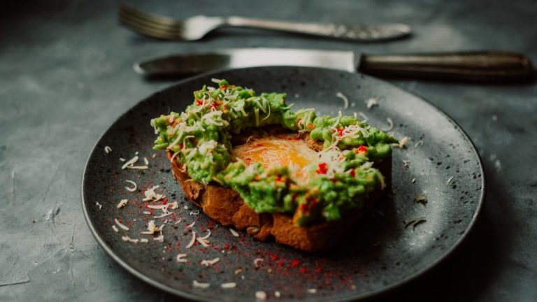 Delicious avocado toast with a poached egg, garnished with spices, perfect for breakfast or brunch.